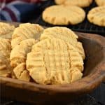 Peanut butter cookies in a brown wooden bowl.