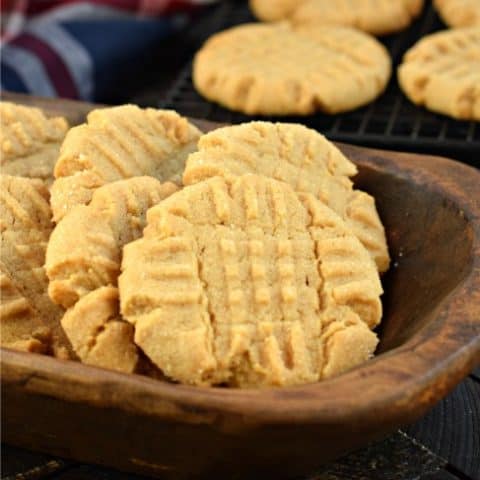 Peanut butter cookies in a brown wooden bowl.