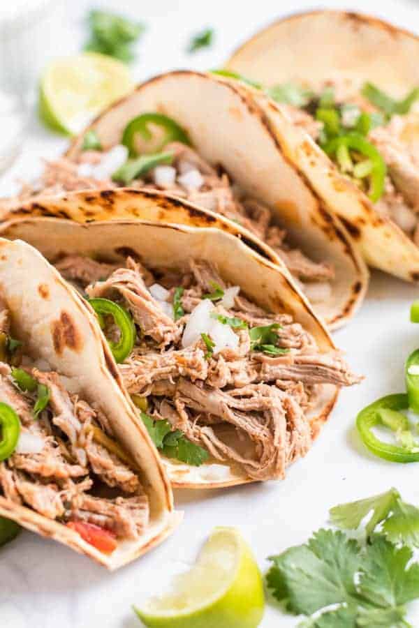 Pork Carnitas on flour tortillas with sour cream, cilantro, and jalapenos