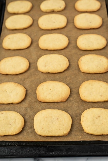 Parchment paper lined baking sheet with cooked cookies.