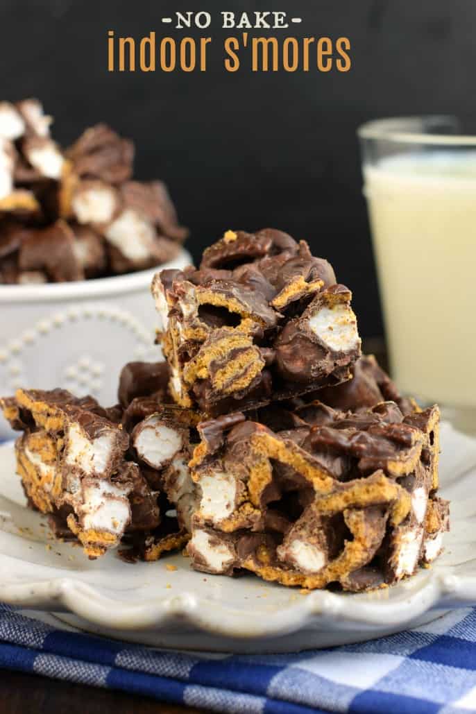 Stack of smores bars cut into squares on a white plate.