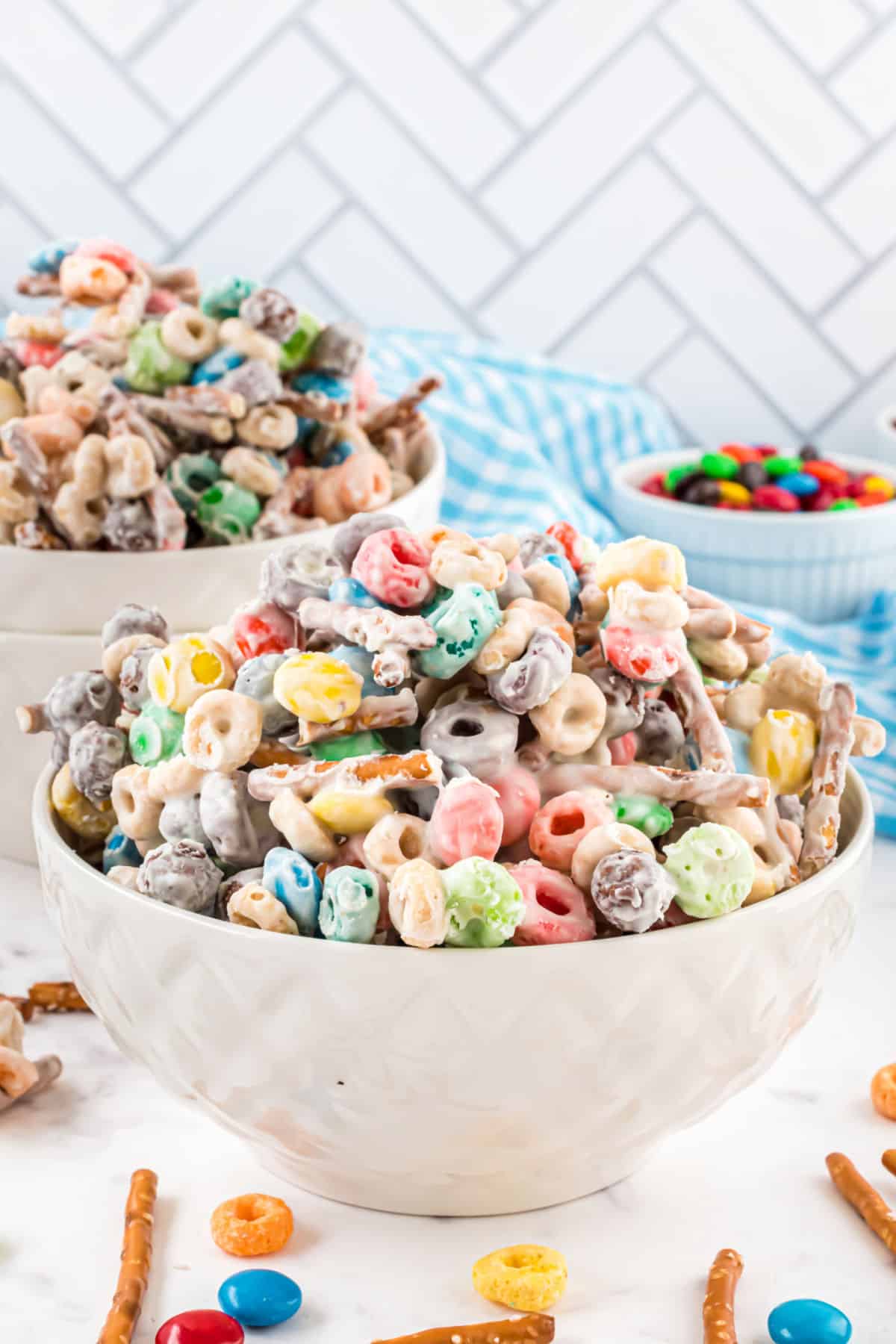 Easy candy mix made with cereal, white chocolate, and m&ms in a white bowl.