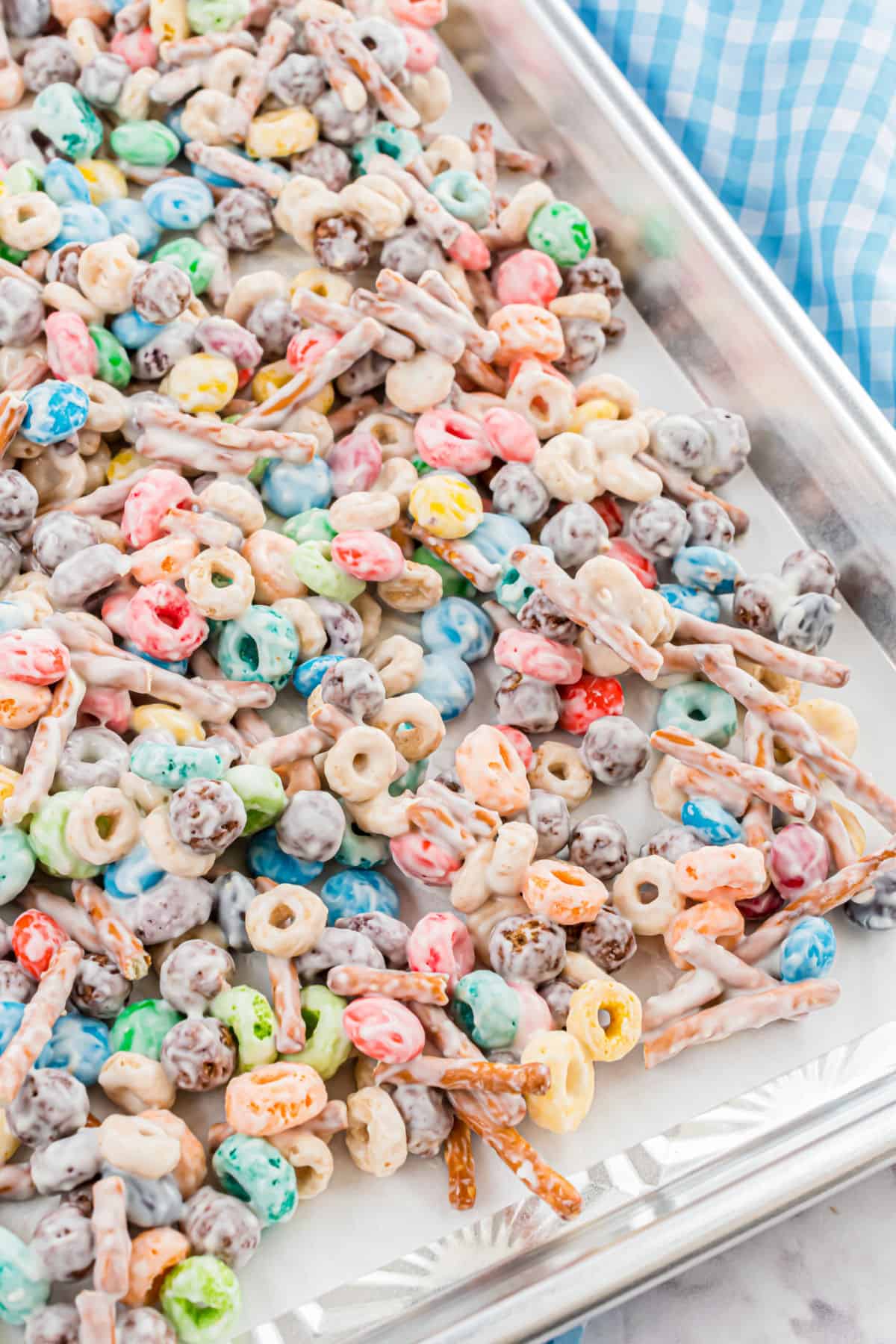 White trash candy mix spread onto a parchment paper lined cookie sheet.