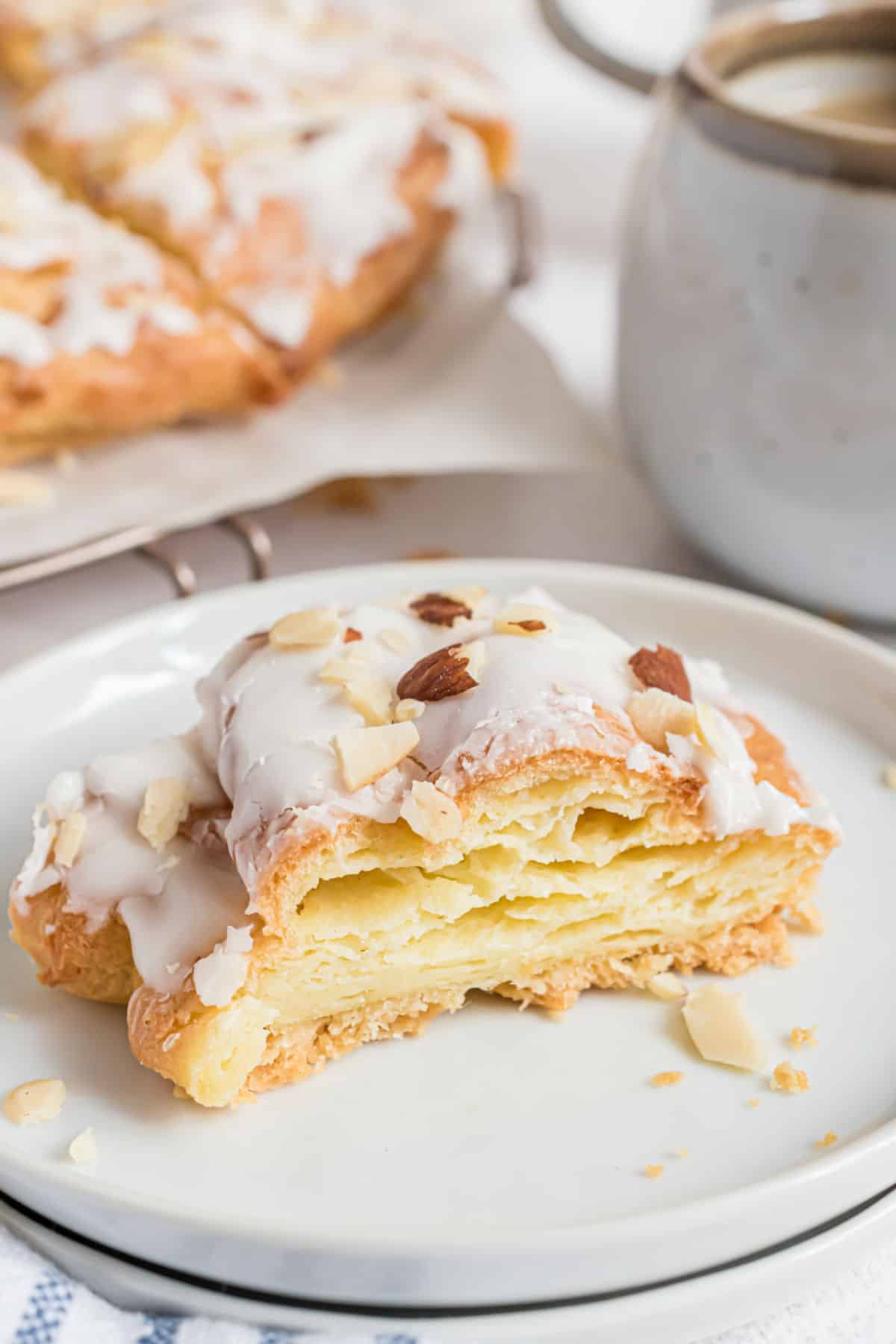 Slice of almond kringle on a white plate.