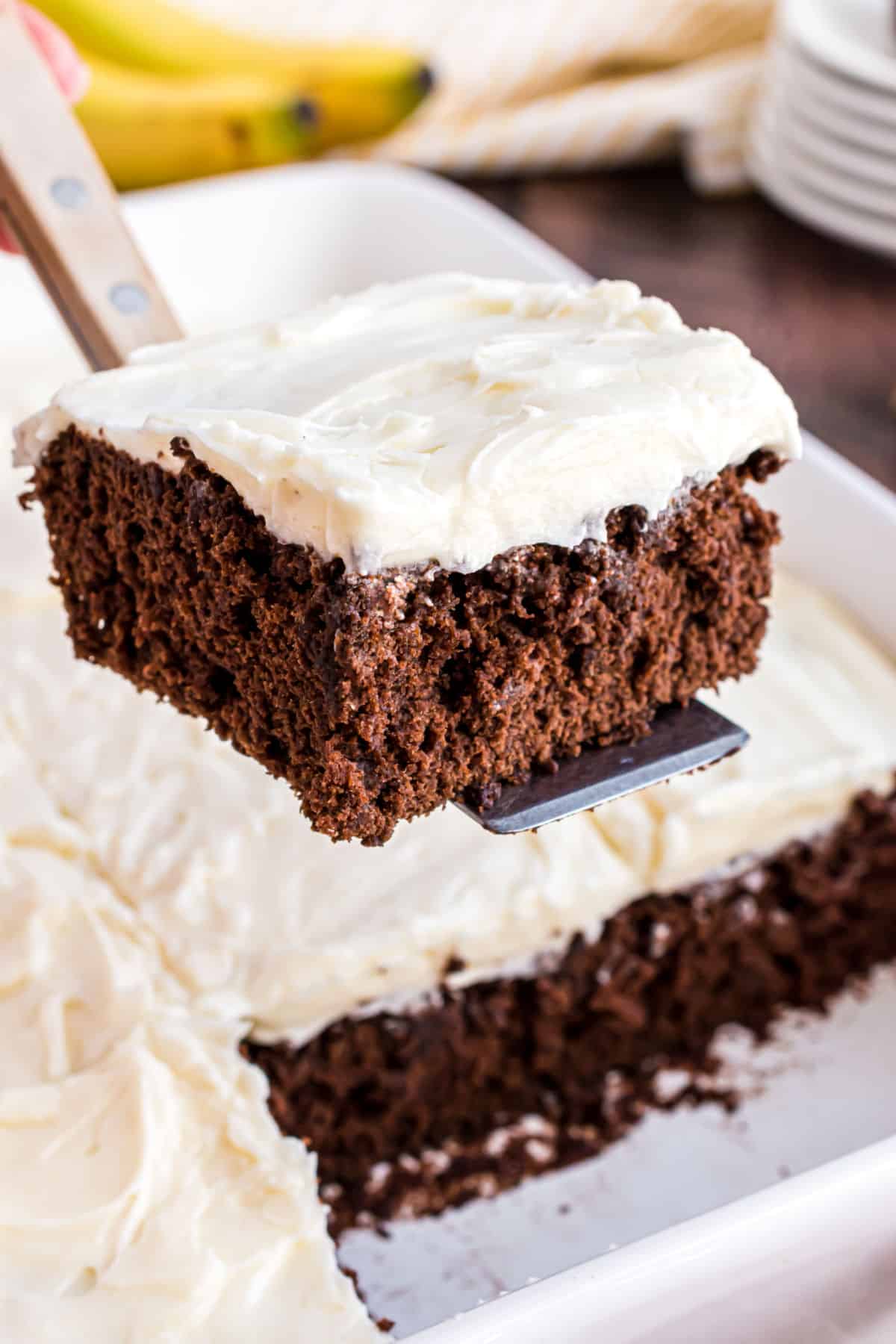 Slice of chocolate banana cake being lifted out of 13x9 pan.