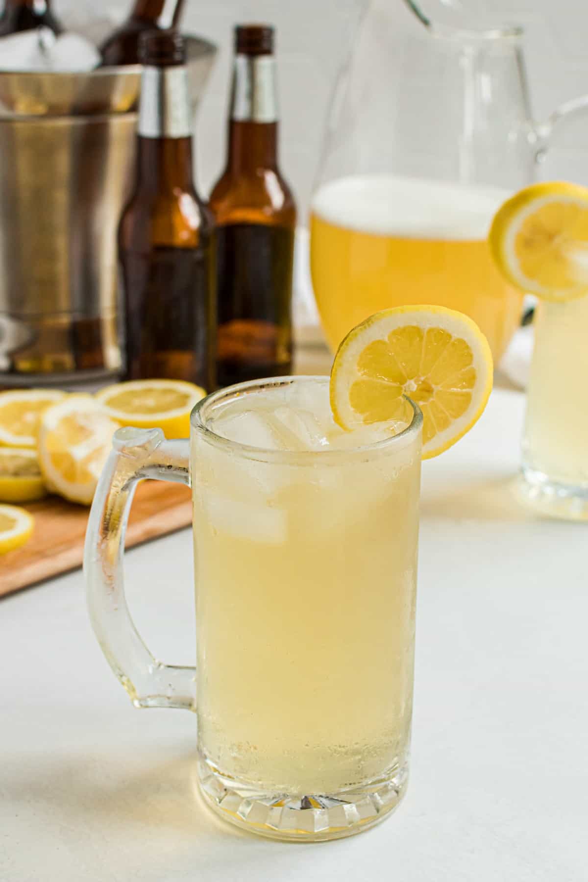 Beer mug with homemade summer shandy, garnished with a lemon slice.