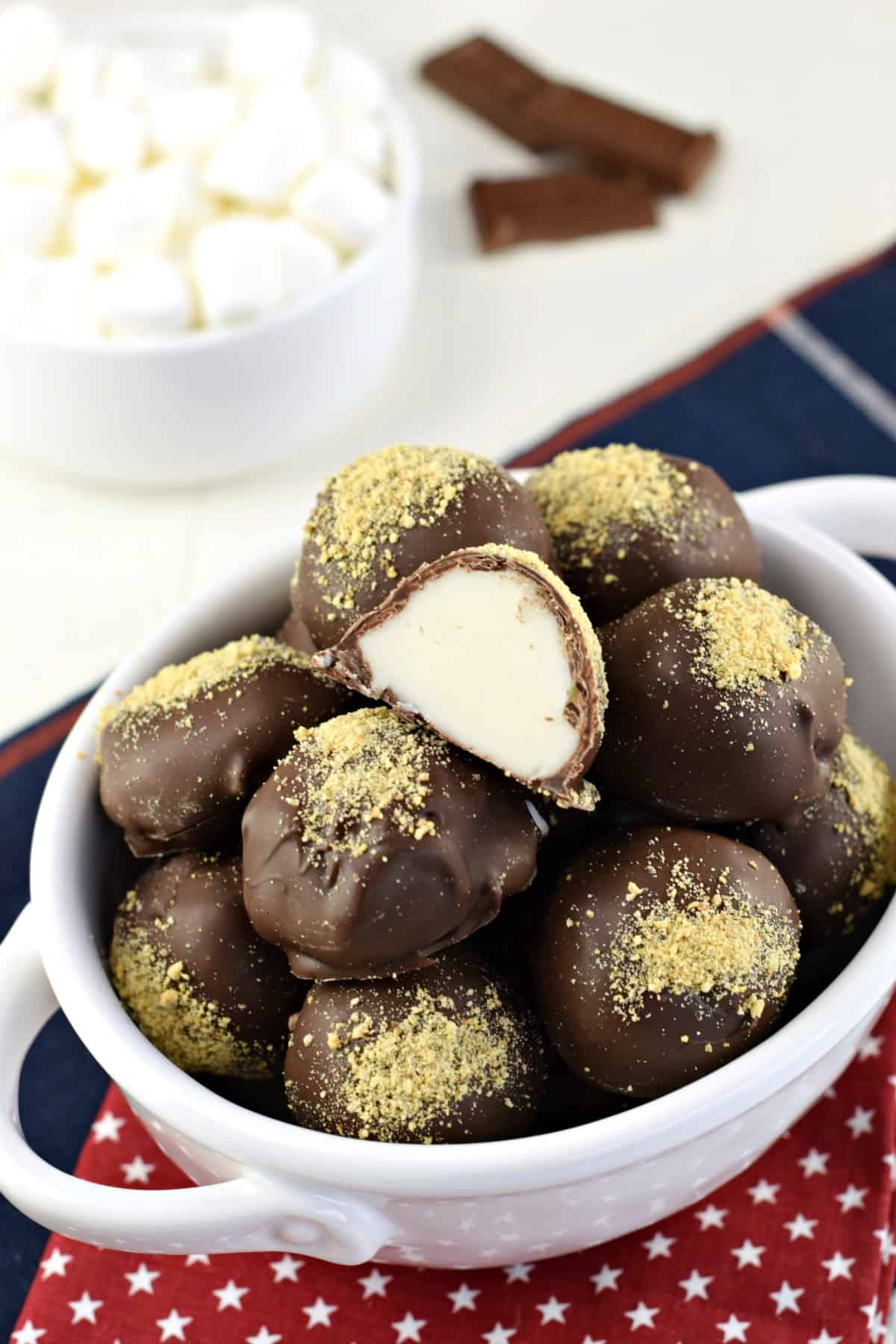 S'more truffles in a white bowl, one cut in half.