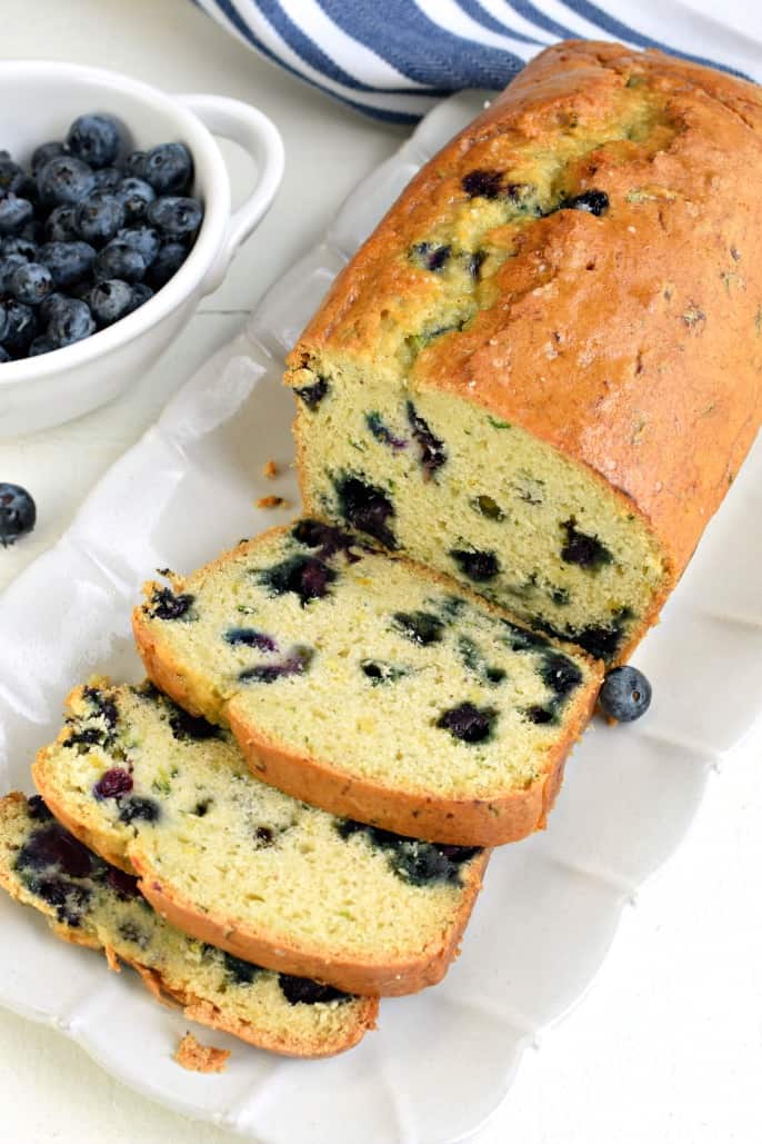 Sliced blueberry zucchini bread on a white plate.