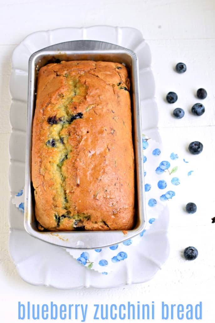 Loaf of zucchini blueberry bread in a metal loaf pan.