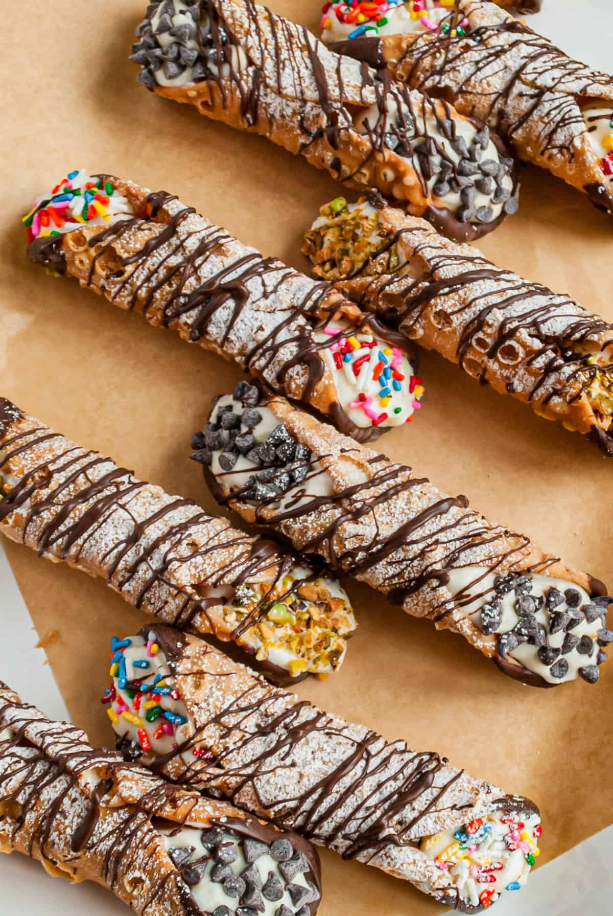Parchment paper lined with filled cannolis drizzled in chocolate.