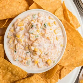 Bowl of corn dip with jalapenos and tortilla chips.