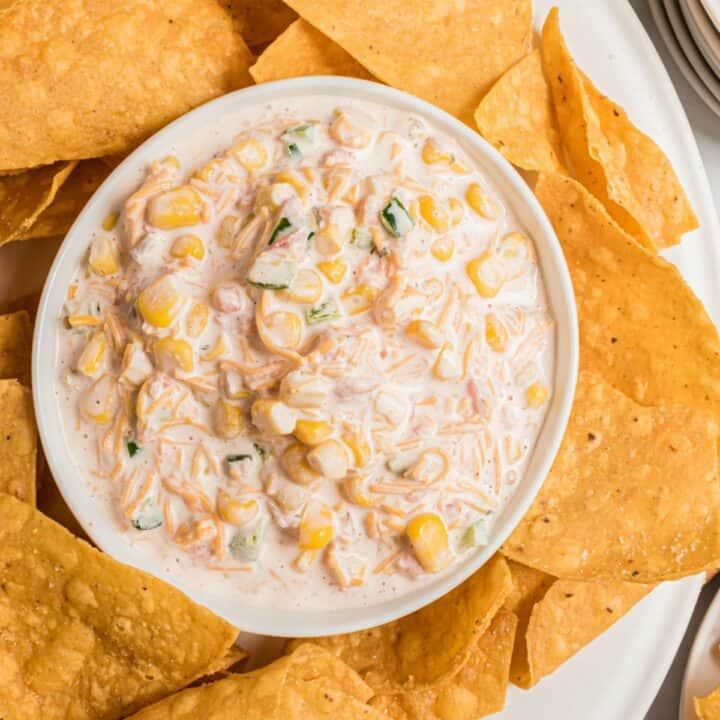 Bowl of corn dip with jalapenos and tortilla chips.