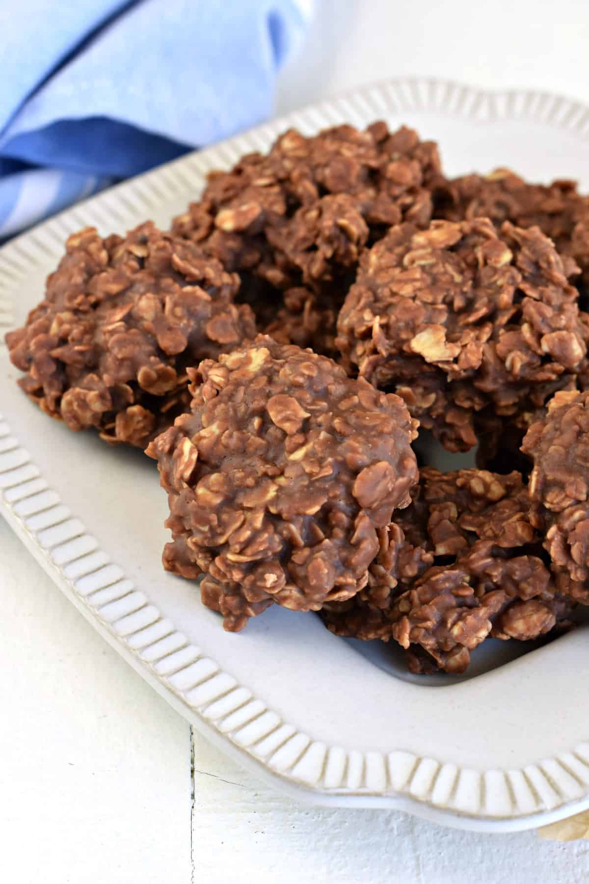 White plate on a light blue linen napkin topped with a stack of no bake chocolate oatmeal cookies with nutella.