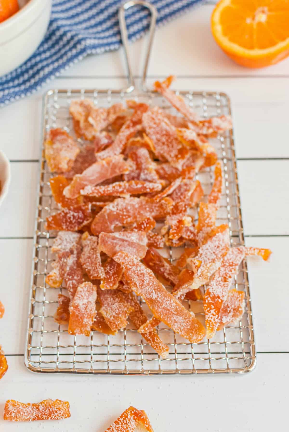 Orange peels covered in sugar on a wire rack to harden.