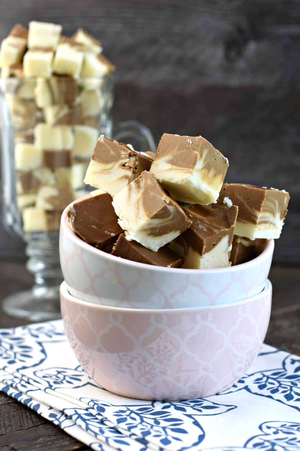 Two stacked pink and white bowls filled with small pieces of root beer float fudge.