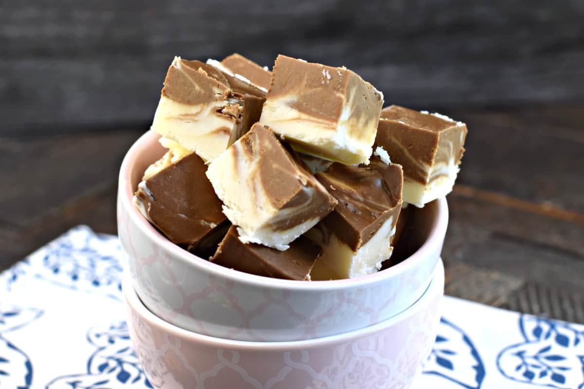 Pieces of root beer float fudge in a stack of small pink and white bowls.