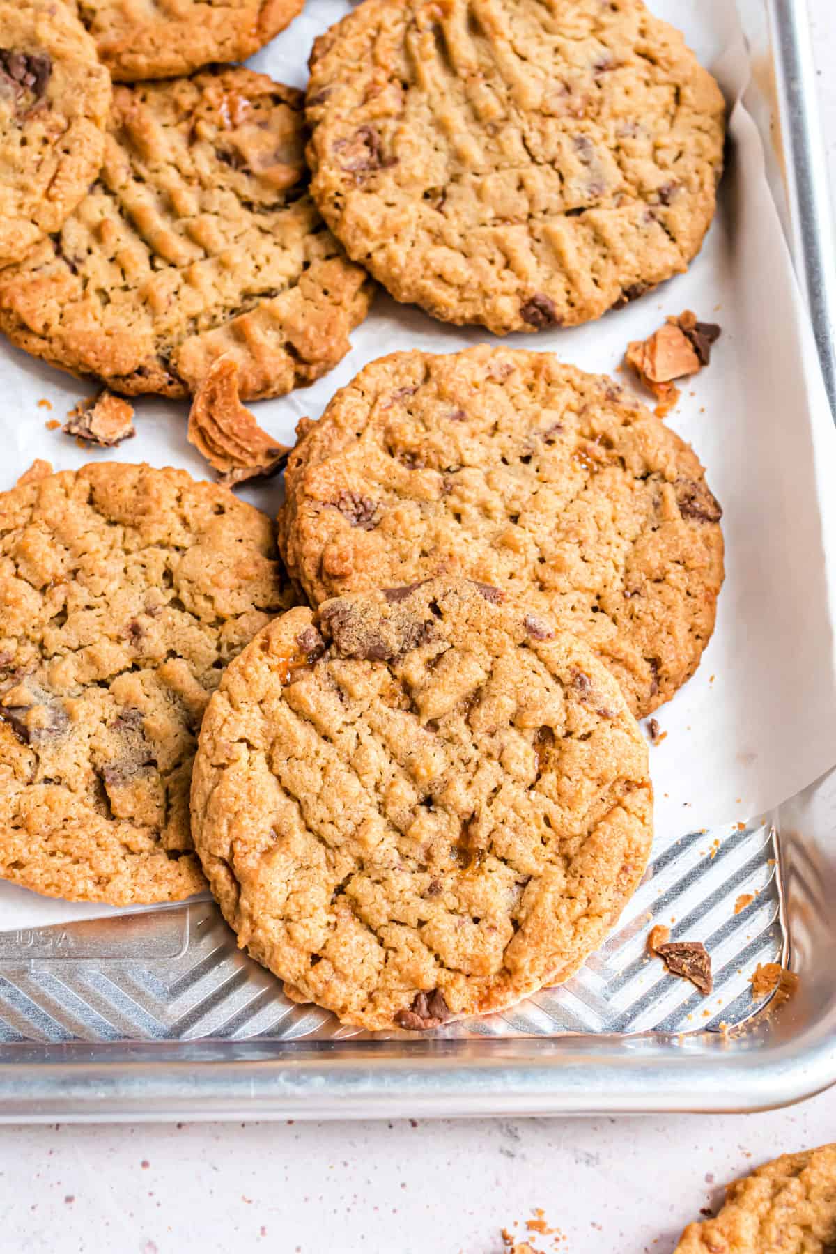 Butterfinger cookies stacked on a cookies sheet.