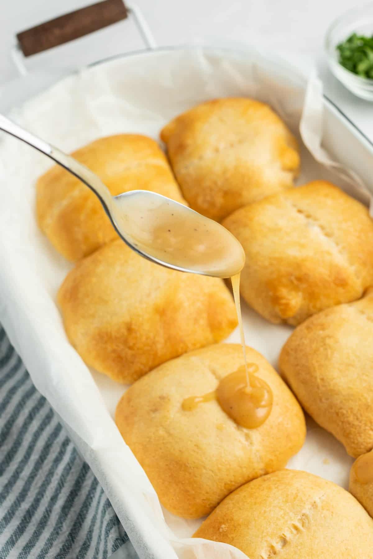 Chicken pockets with a spoonful of gravy being drizzled over the top.