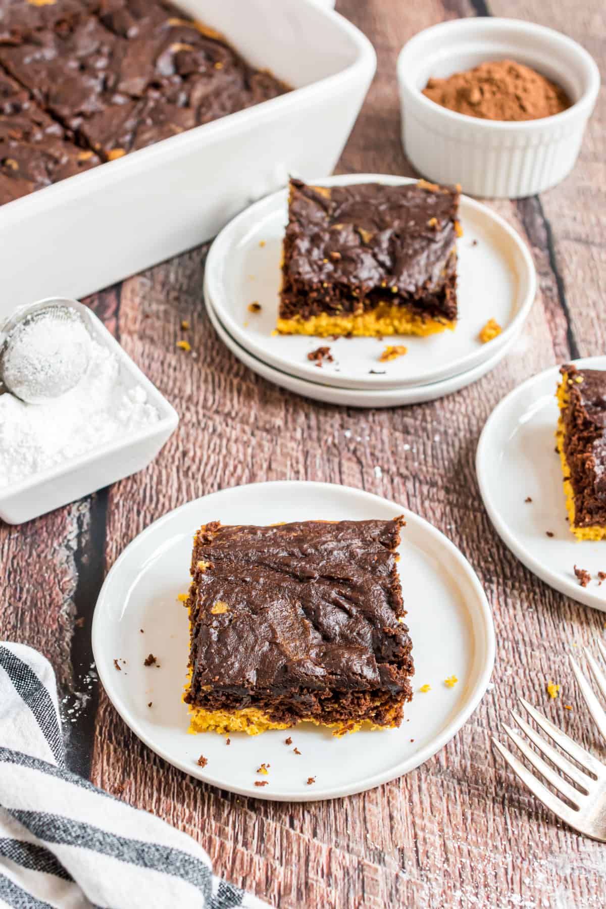 Two slices of chocolate pumpkin cake on white dessert plates.