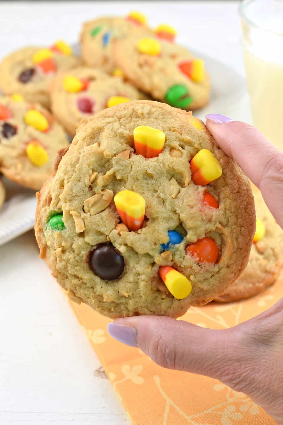 Hand holding a pay day cookie up close.