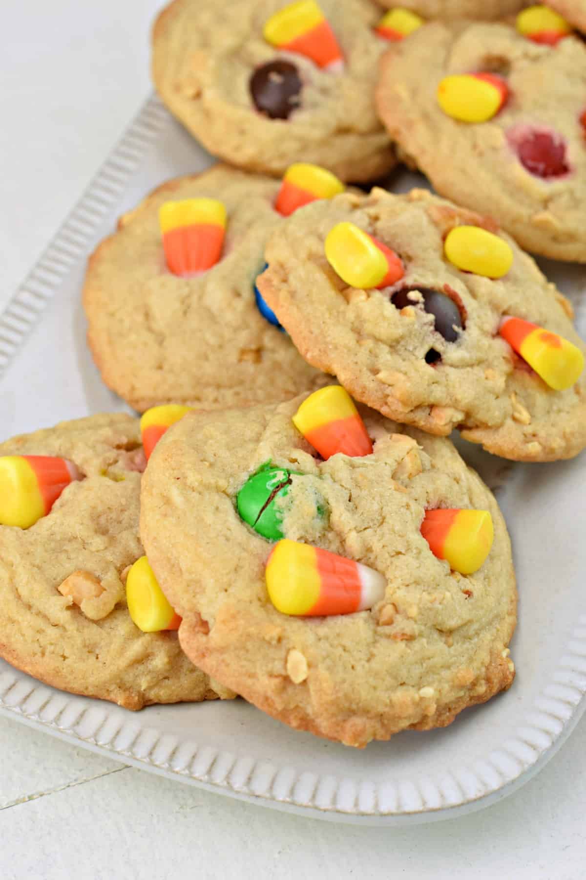 Pay day cookies with candy corn on a white rectangle plate.