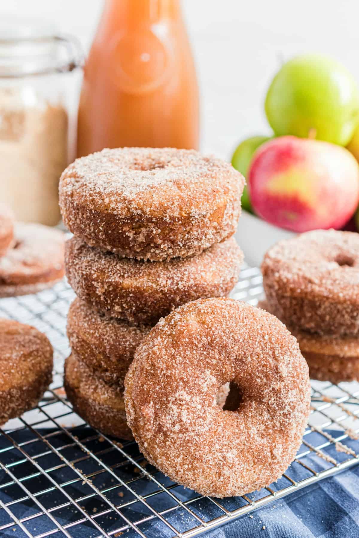 Stack of apple cider donuts on a wire rack with one tilted sideways.