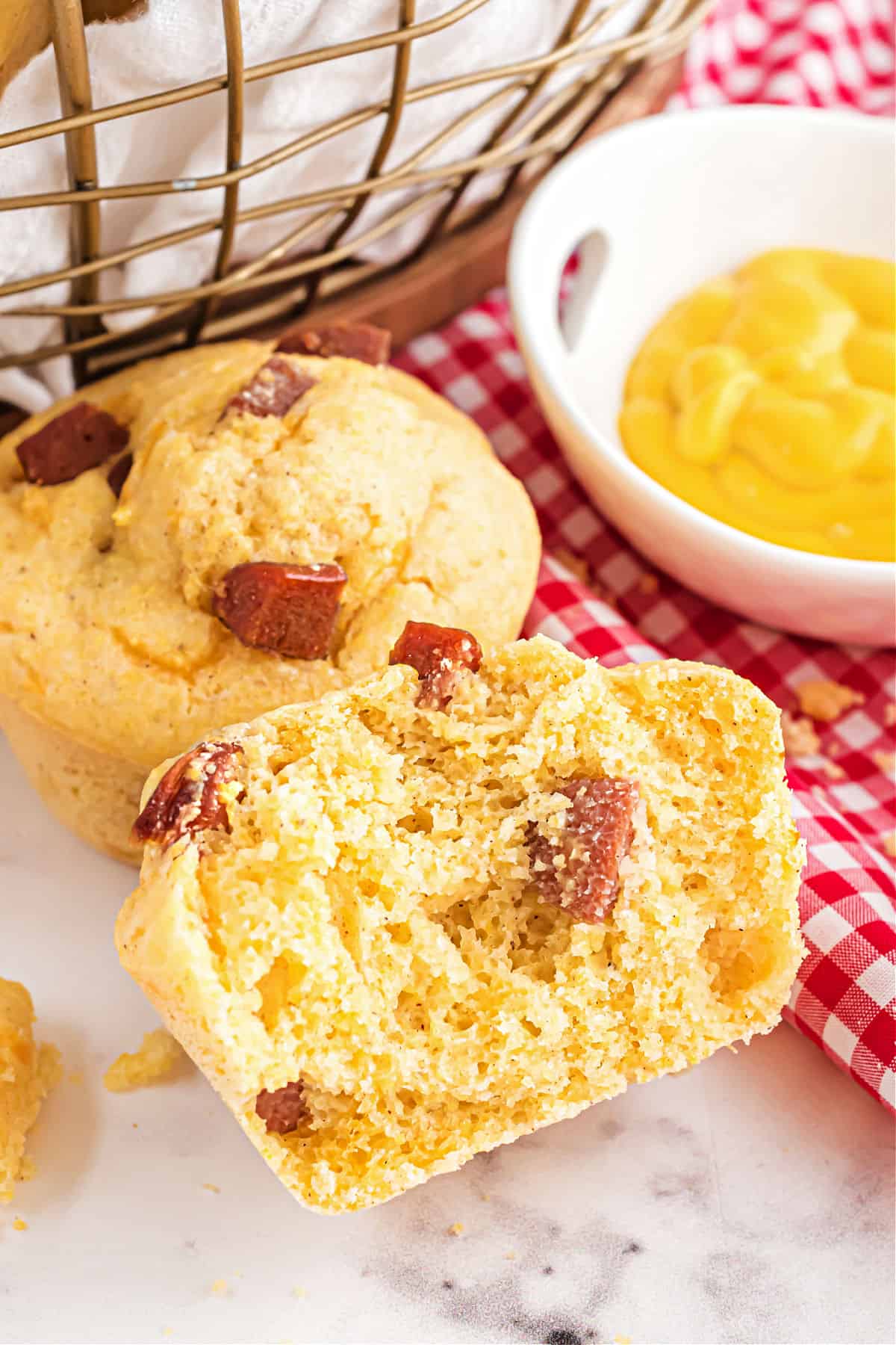 Corn dog muffin cut in half with a side of mustard.