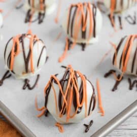 Pumpkin pie truffles on parchment paper lined baking sheet.