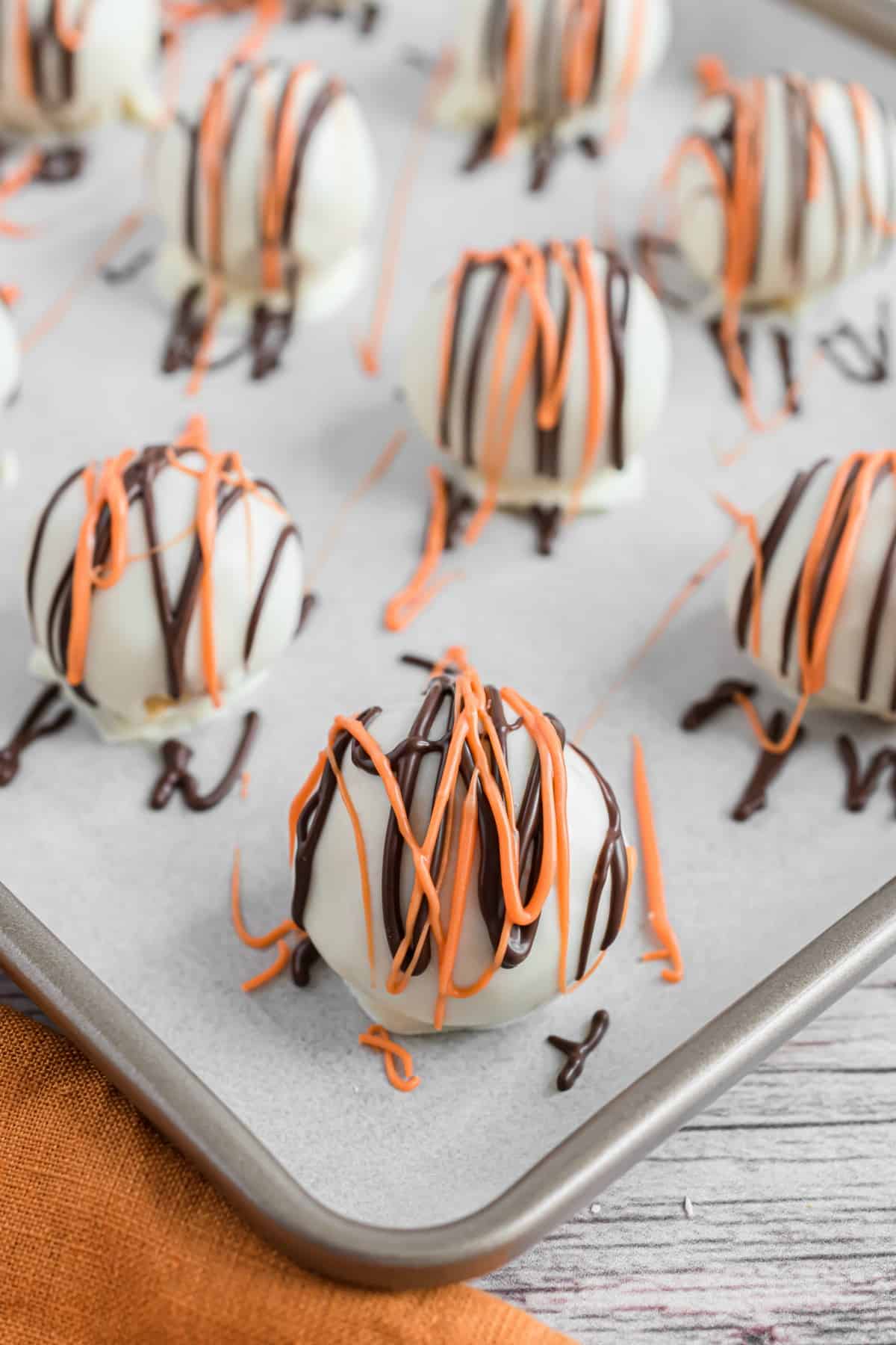 Pumpkin pie truffles on parchment paper lined baking sheet.