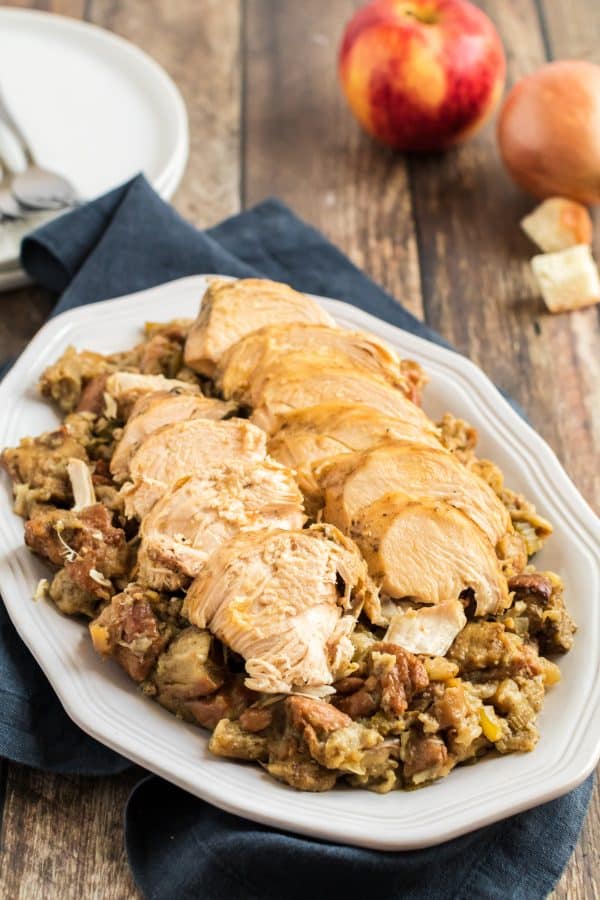 Large rectangular white platter topped with stuffing and turkey breast.