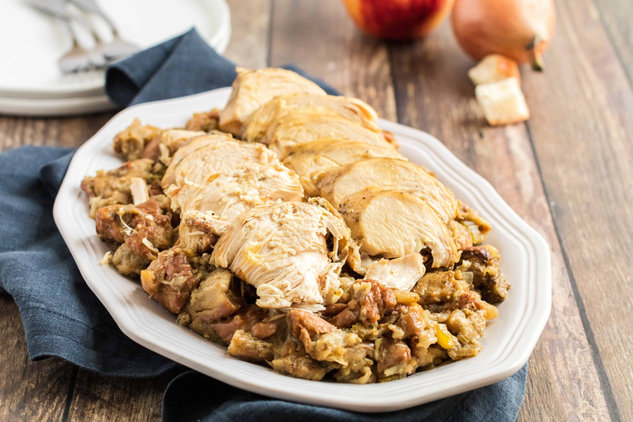 Sliced turkey breast on a plate of stuffing.