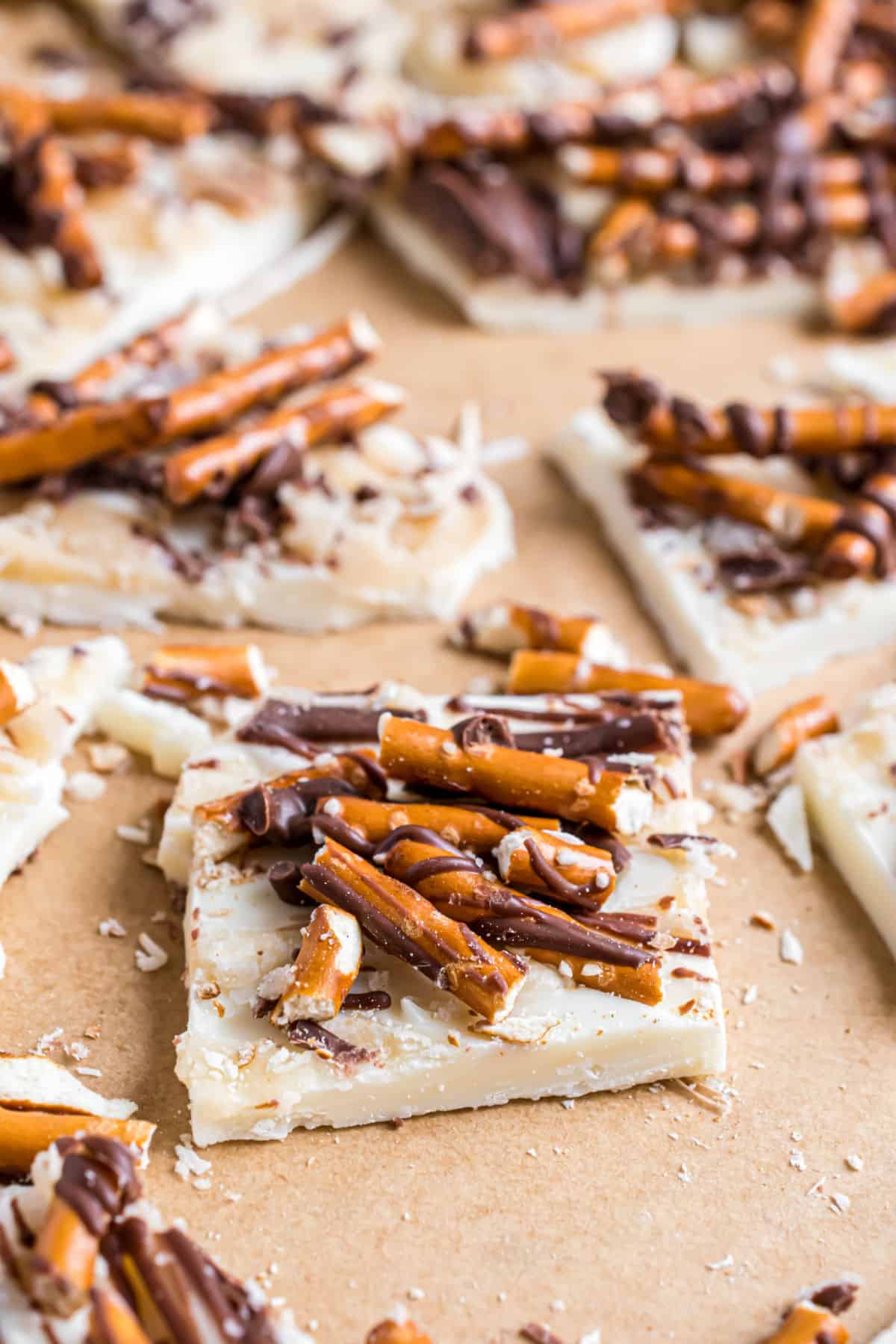 Pieces of salted caramel white chocolate candy topped with pretzels and milk chocolate.