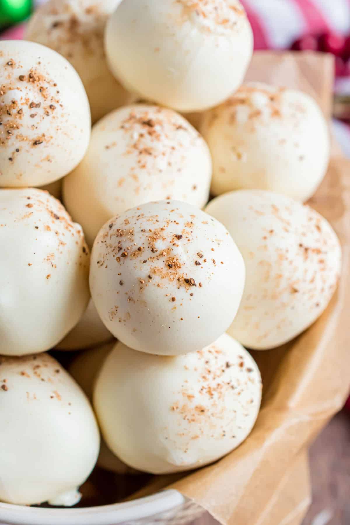 Eggnog truffles in a bowl with a pinch of nutmeg.