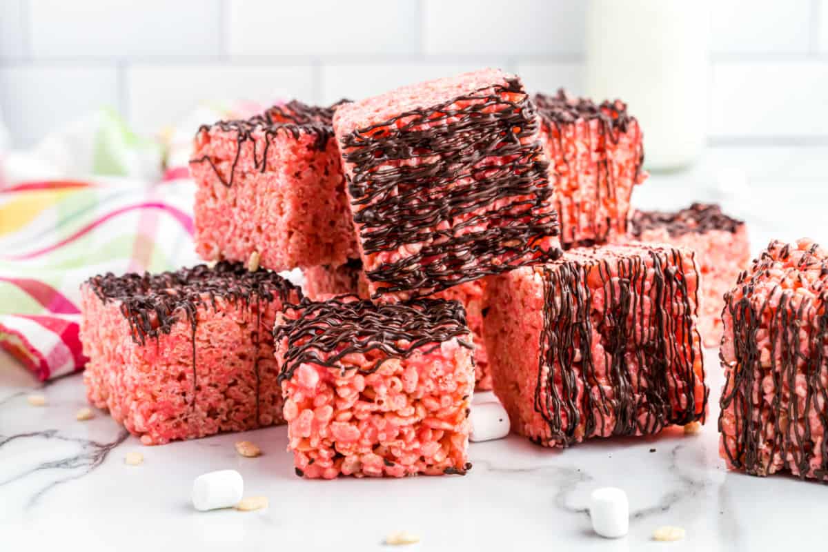 Cherry krispie treats with chocolate drizzle stacked.