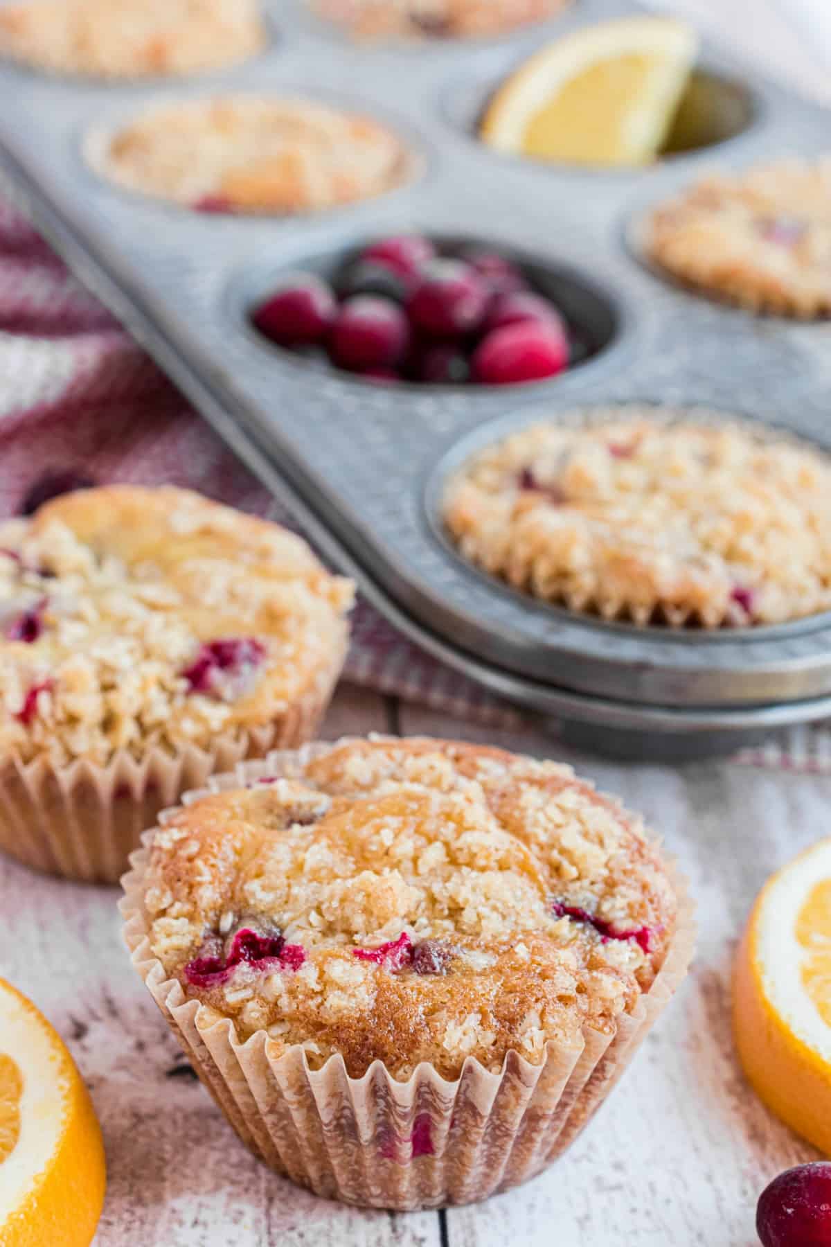 Cranberry orange muffins on counter with muffin pan in background.