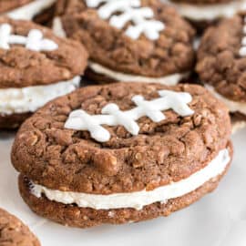 Football shaped oatmeal cream pies on white cake platter.