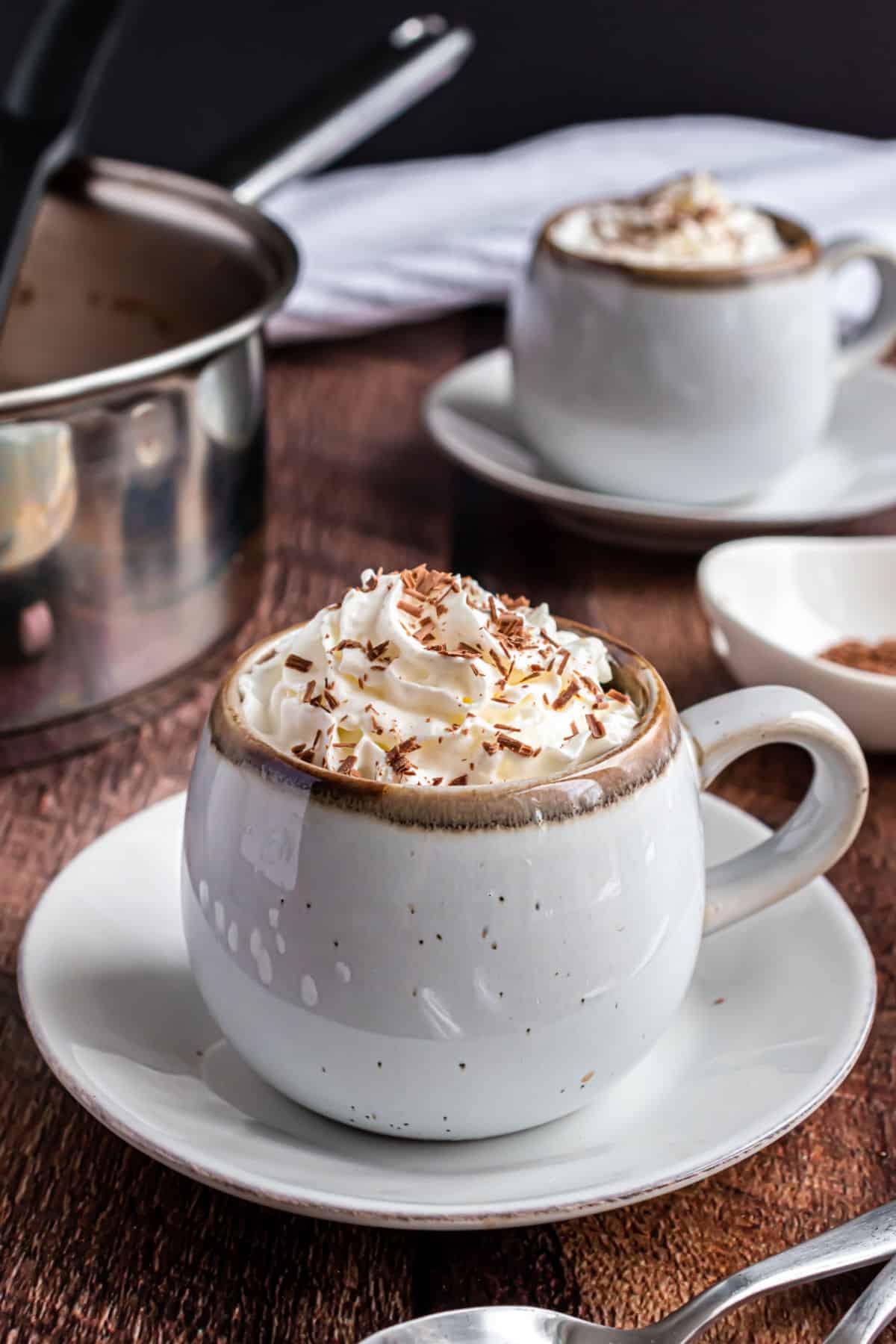 Hot chocolate with whipped cream in a ceramic white mug.