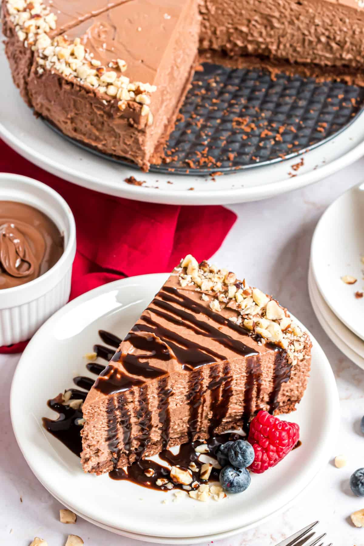 Slice of chocolate hazelnut tarte on a plate with chocolate ganache.