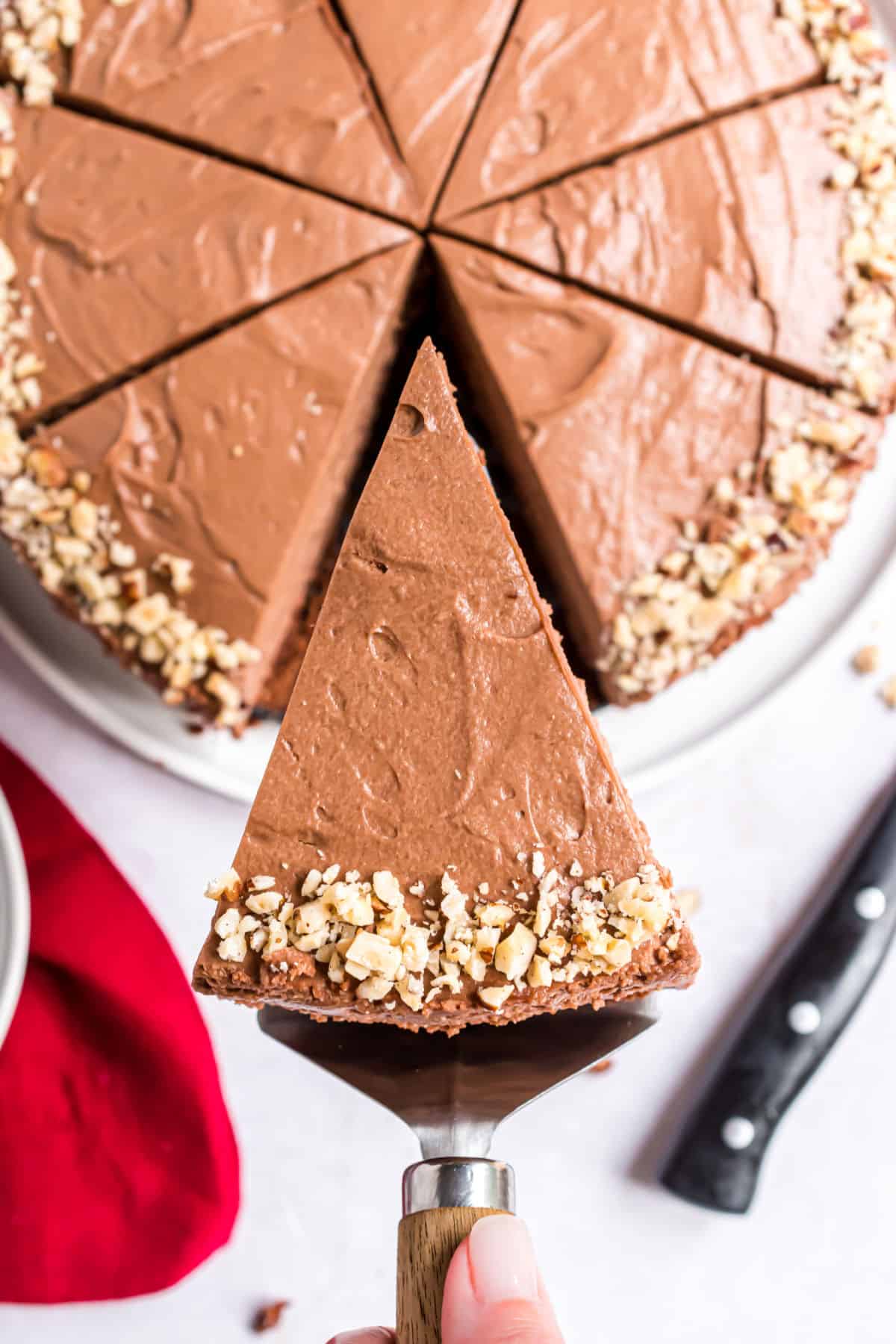 Hazelnut tarte cut into slices with one being removed on spatula.