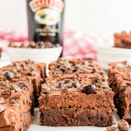 Brownie with frosting, espresso beans and a bottle of Baileys in background.