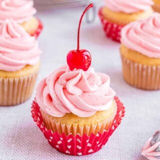 Almond cupcakes topped with cherry buttercream frosting.