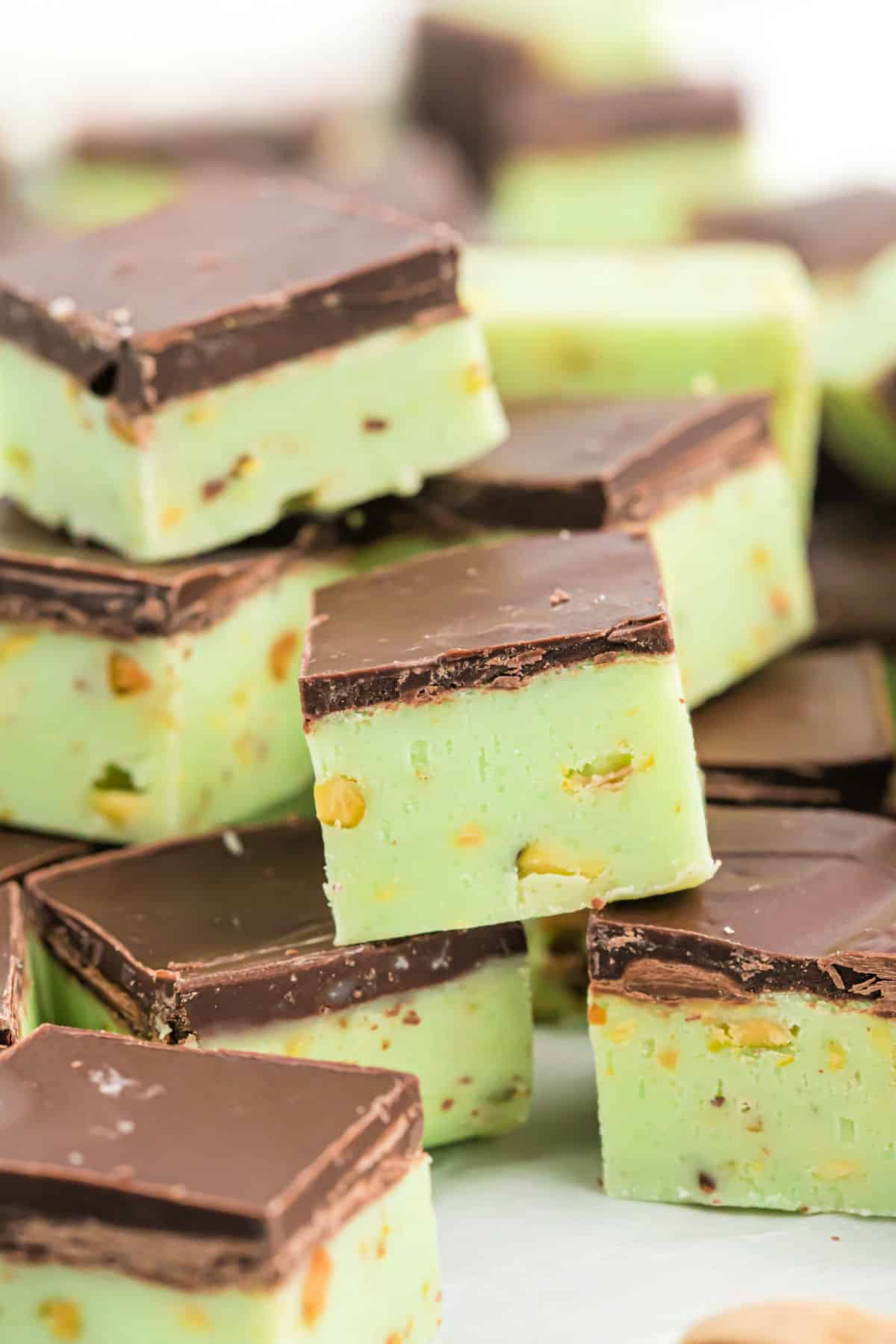 Pieces of pistachio fudge with dark chocolate cut into squares.