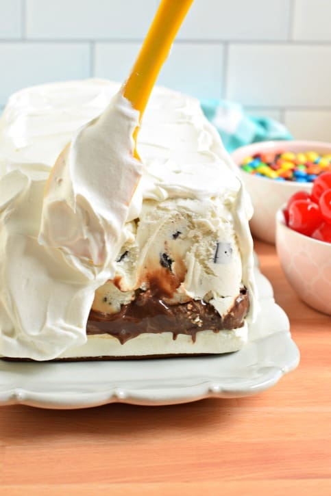 Apply whipped cream or cool whip to out surface of ice cream cake