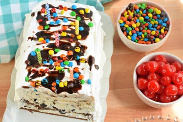 Ice cream cake topped with hot fudge and m&m candies.