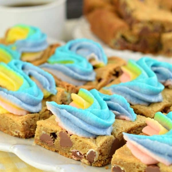 Soft and chewy M&M Cookie bars topped with a sweet rainbow buttercream frosting. These Rainbow M&M Cookie Bars are dreamy and delicious!