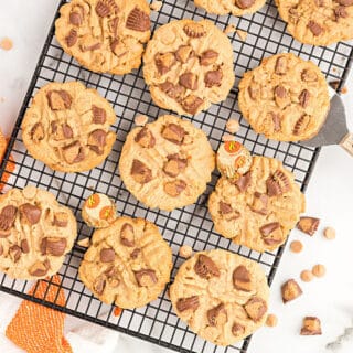 Peanut butter cookies with reeses peanut butter cups on a wire rack.