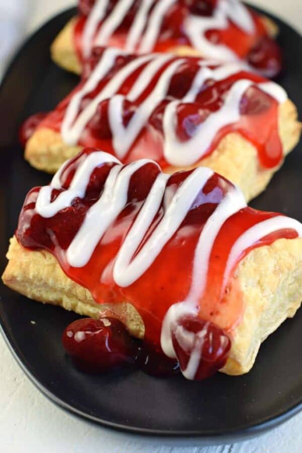 Puff pastry topped with strawberry pie filling and vanilla icing.