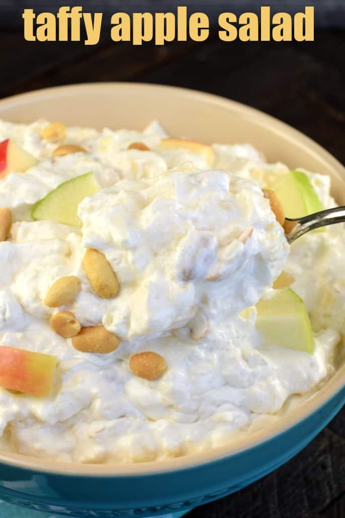 Spoonful of taffy apple salad being scooped out of blue bowl.