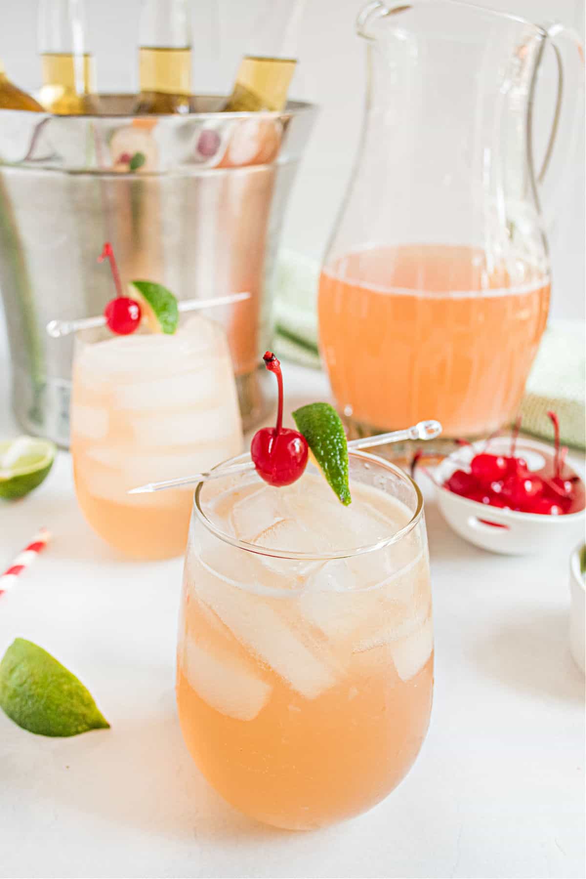 Cherry margaritas in a glass garnished with lime and maraschino cherries.