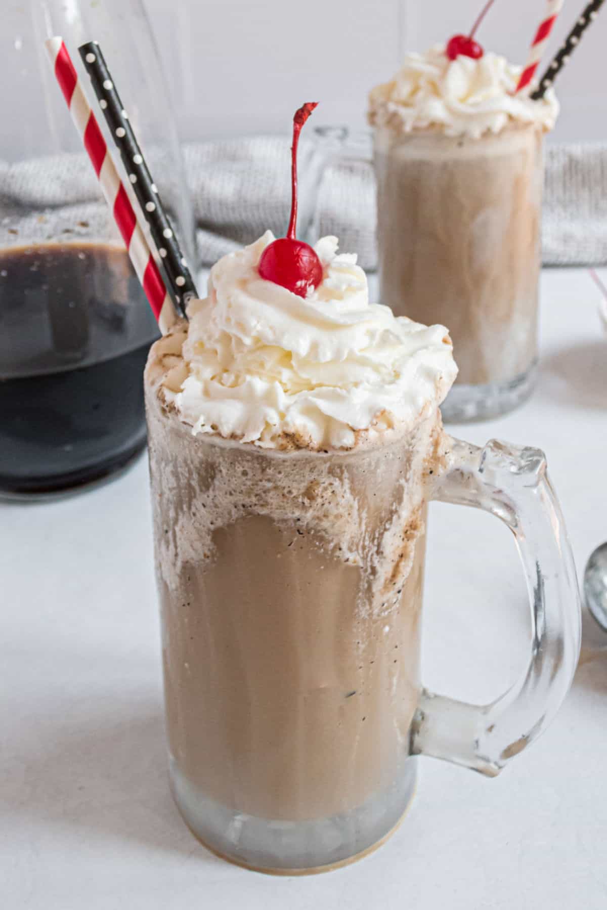 Homemade root beer with vanilla ice cream topped with whipped cream and cherry.